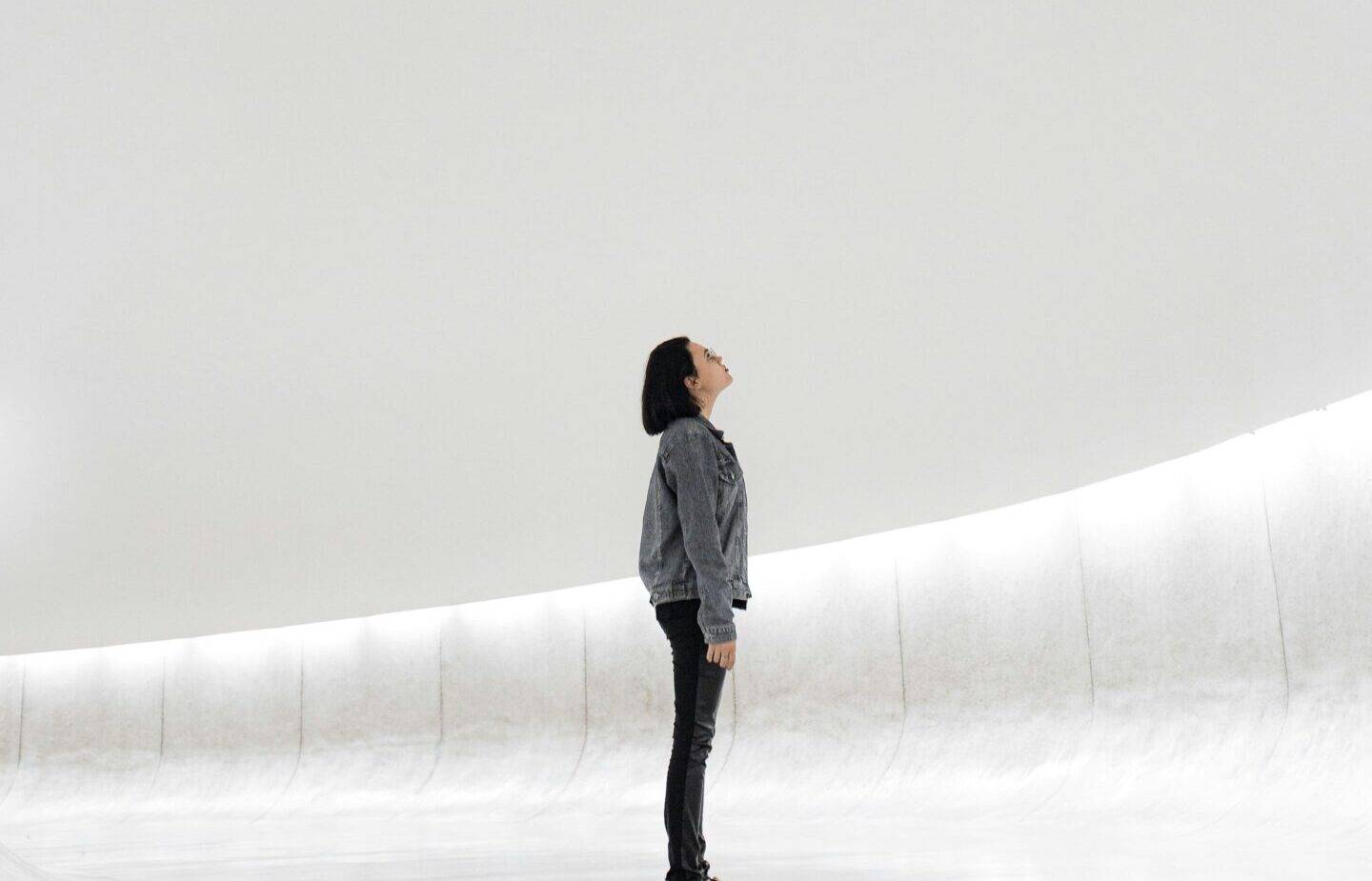 Woman looking up, isolated in a bland white area
